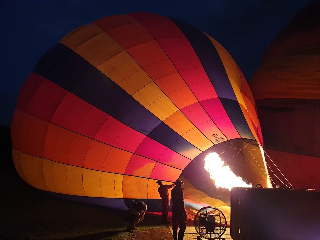 A man lighting up a hot air balloon at Little Governors' Camp