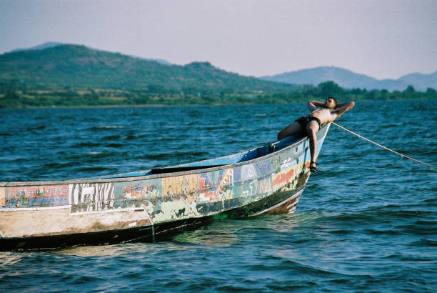 Man lying sunbathing on Traditional Fishing Boat on Lake Victoria