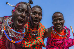 Maasai Mara man in traditional colorful clothing showing traditional Maasai jumping dance at Maasai Mara tribe village famous Safari travel destination near Maasai Mara National Reserve Kenya