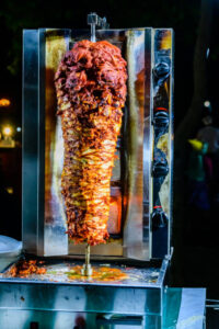 Arabic shawarma meat preparing on skewer at street food restaurant at Forodhani gardens. Zanzibar, Tanzania