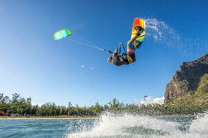professional kiter makes the difficult trick on a beautiful background of spray and beautiful mountains of Mauritius
