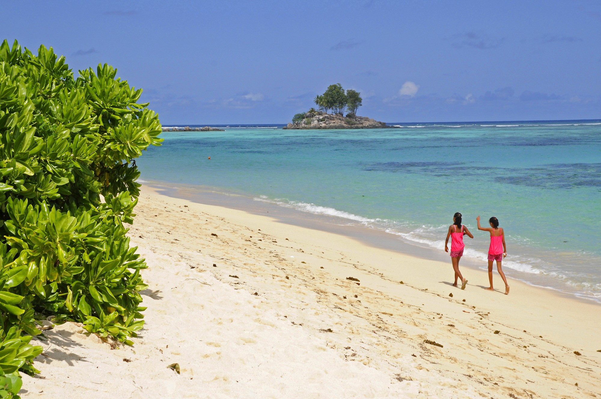 Pair walking along Anse aux Pins Beach in Seychelles.