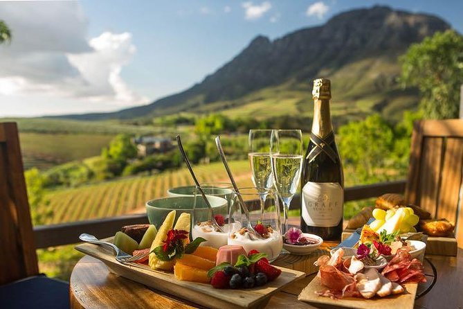 A beautifully set table featuring an array of food and wine, showcasing the culinary delights of Cape Town and the Winelands.
