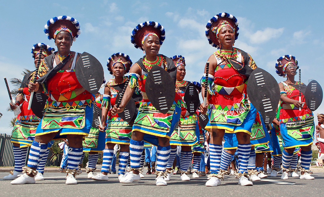 A vibrant group of women in traditional South African costumes, showcasing cultural heritage and historical significance.
