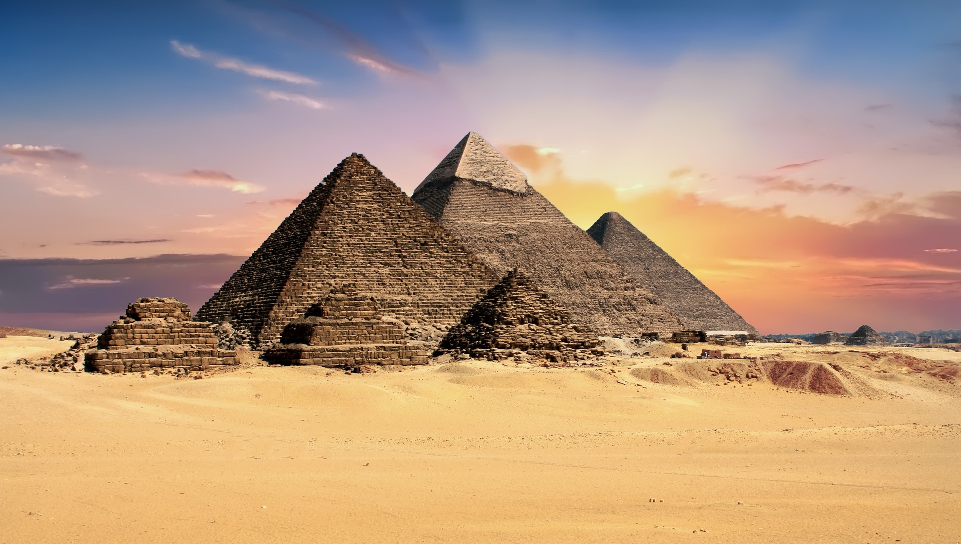 The Great Pyramids of Giza, Egypt, stand majestically against a clear blue sky, showcasing ancient architectural marvels.