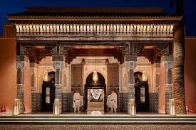 The illuminated entrance of La Mamounia hotel in Marrakech, showcasing elegant architecture against a night sky.