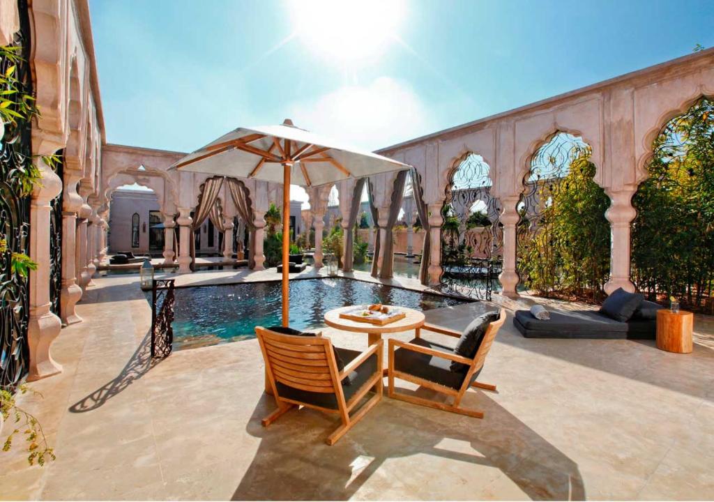A serene pool area at Riad Al-Sakhr, featuring elegant design and lush surroundings at Palais Namaskar, Marrakech.