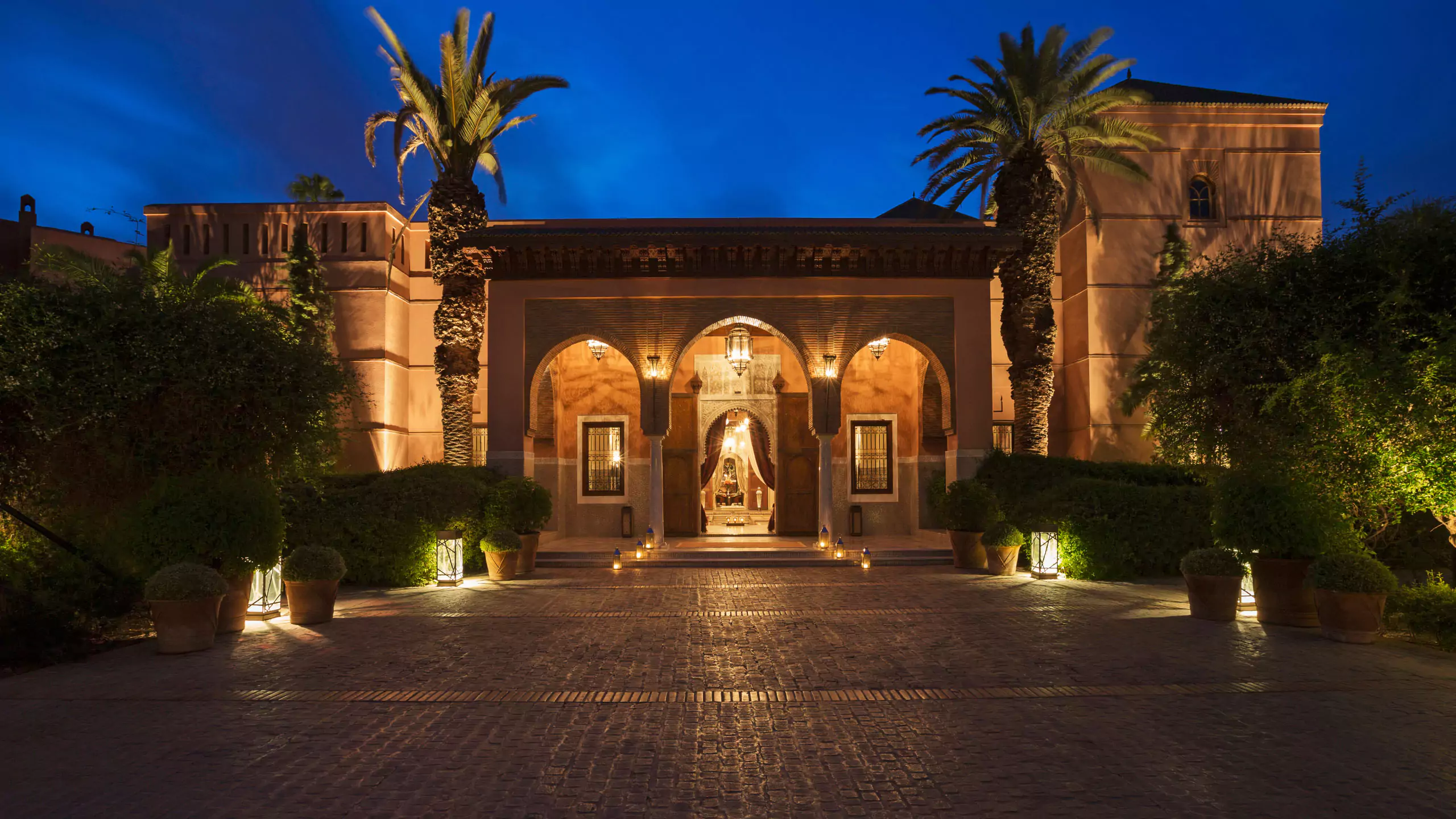 The grand entrance of Royal Mansour in Marrakech illuminated at night, showcasing its architectural elegance and opulence.