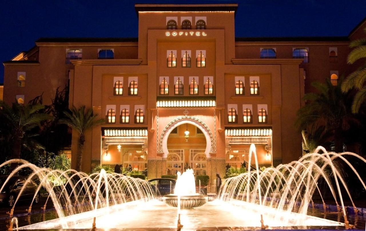 The Sofitel Marrakech Palais Imperial illuminated at night, featuring a stunning fountain in the foreground.