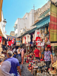 Tunis, Tunisia - 27 August, 2022: People walking in the medina quarter. The Medina contains some 700 monuments, including palaces, mosques, mausoleums, madrasas and fountains.