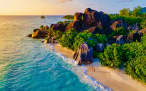 Anse Source d'Argent beach, La Digue Island, Seychelles, aerial view of La Digue Seychelles a tropical Island, couple men and woman walking at the beach during sunset at a luxury vacation, drone view