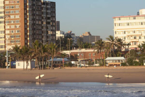 Durban, South Africa - April 13, 2006: Surfers walk along the North Beach beachfront in the coastal city of Durban